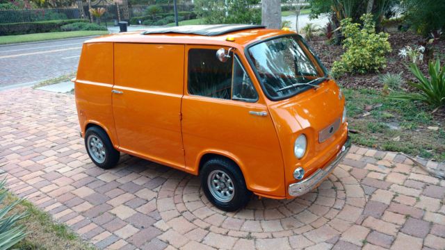 an orange van is parked on a brick walkway