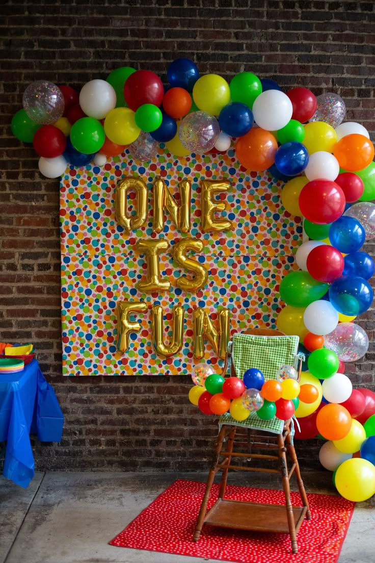 a birthday party with balloons and confetti on the wall, including one is gold