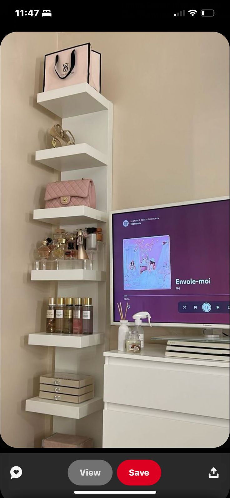 a flat screen tv sitting on top of a white shelf