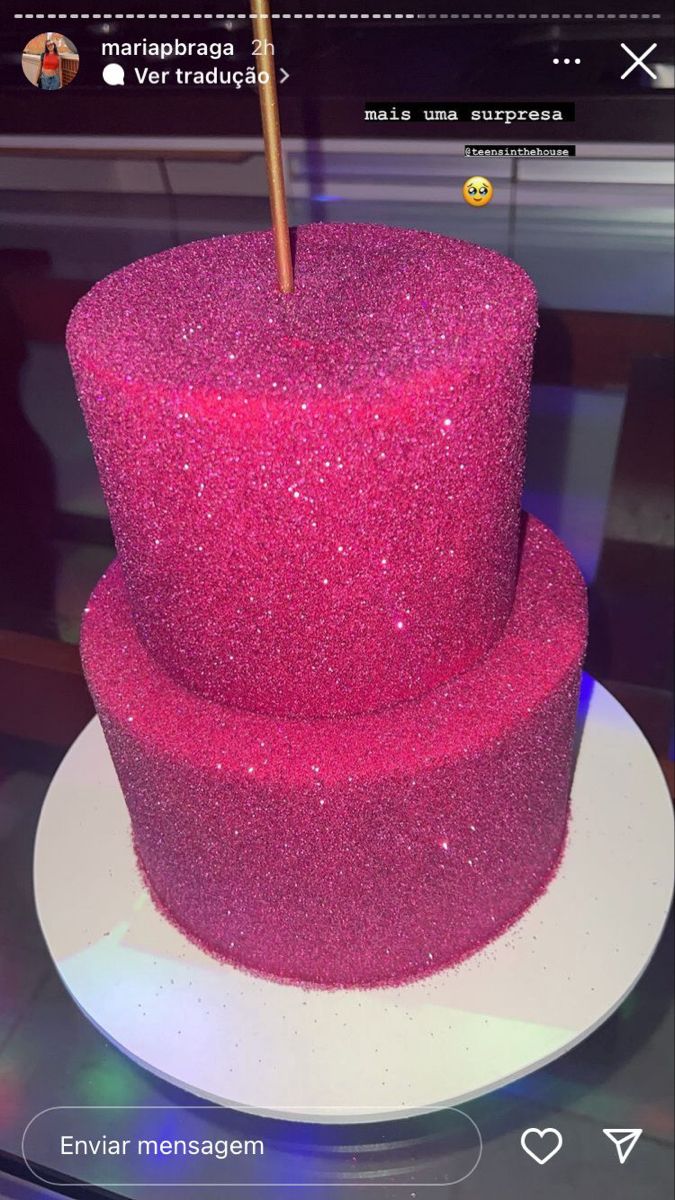 a three tiered cake with pink glitter on it's sides and a gold stick sticking out of the top