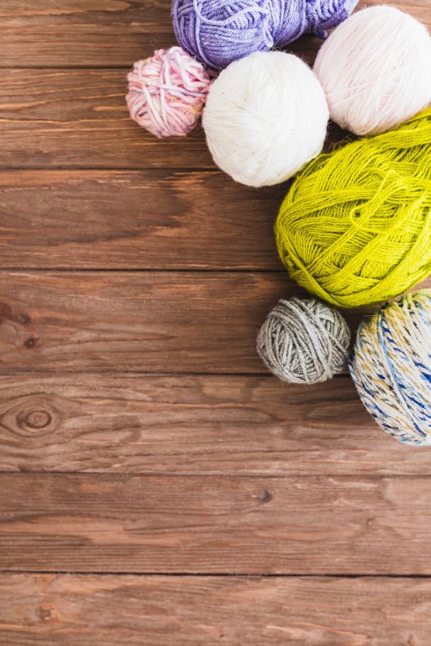 several balls of yarn on a wooden surface