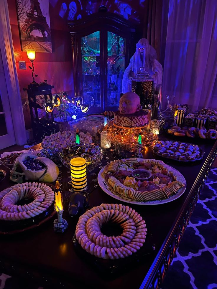 a table is set up with plates and candles for halloween dinnerware, including candy