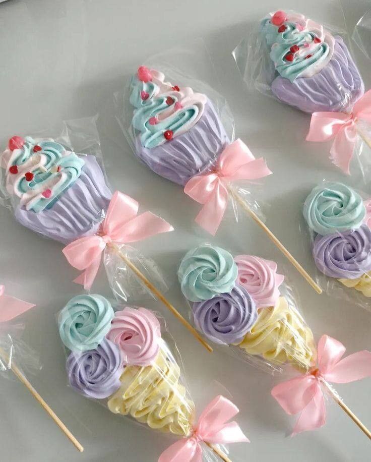 there are many cupcakes on sticks with bows