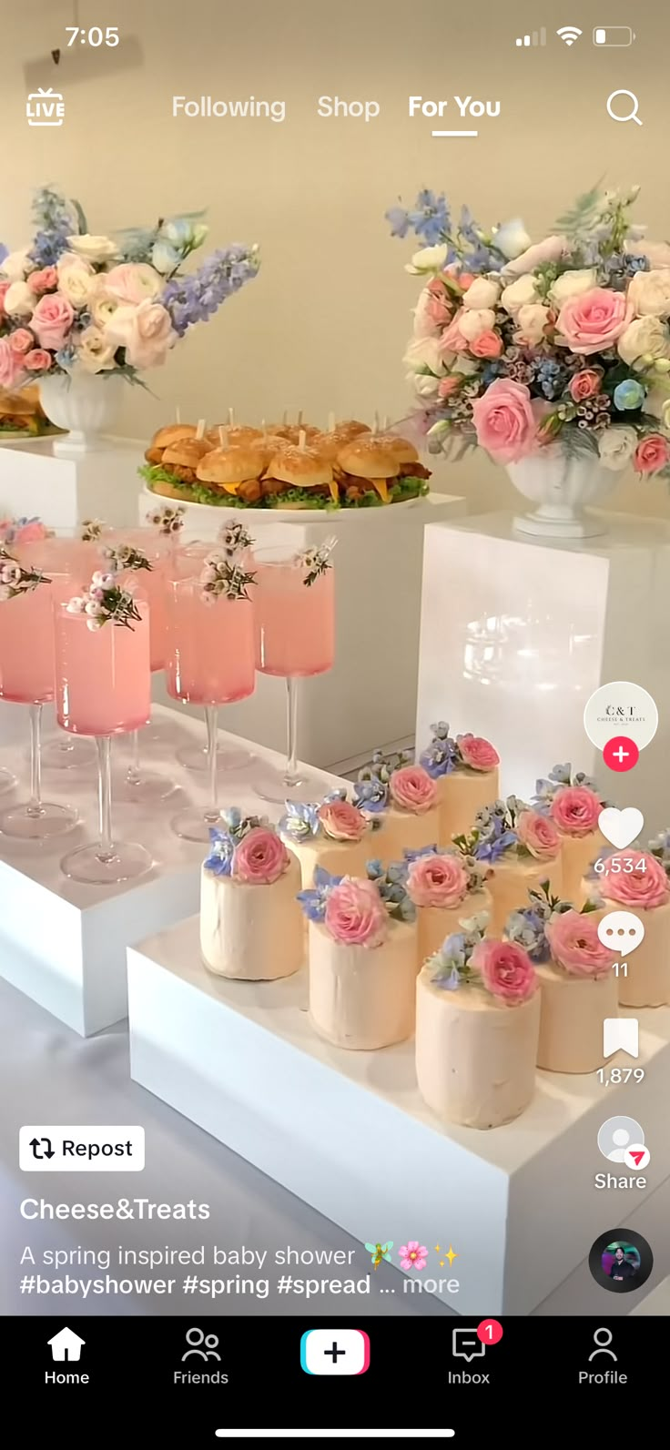 a table topped with lots of desserts next to tall vases filled with flowers