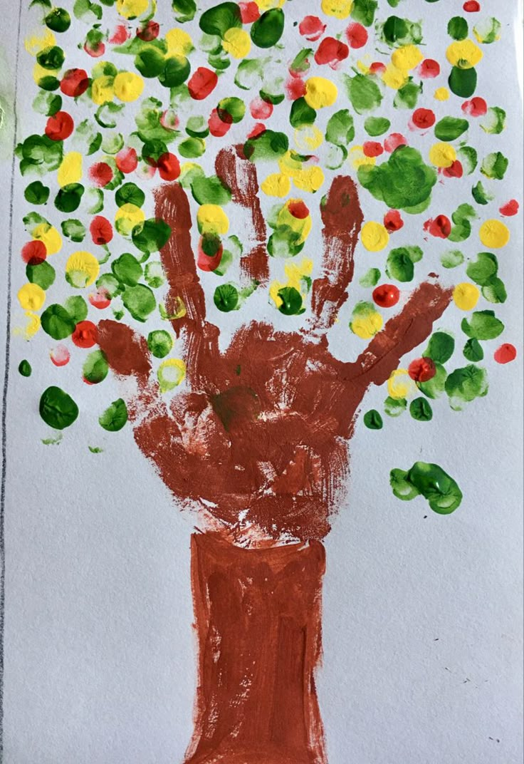 a child's handprint tree made with colored paper and watercolor pencils