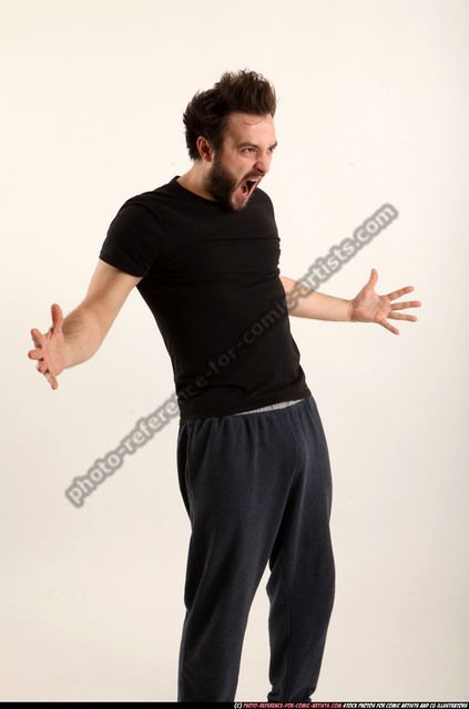 a man in black shirt and sweatpants holding his arms out