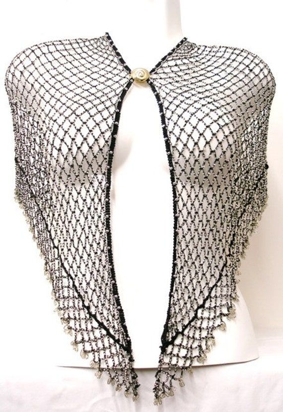 This shawl can be worn also as a wrap. The length of the shawl from hook to eye is approx. 33 inches, and there is a 4 inch extension on both sides.Using these extensions, you can move the eye and hook to suit your waist measurements. When worn on the hips, the center length is 9 inches in the center and 6 inches towards the eye and the hook (Excluding fringes) .All descriptions are approximate or estimate only. Shawl With Arm Holes, Silver Shawl, Black One Size Shawl Wrap, Spider Web Shawl, Elegant One-size Cape Shawl, Black Shear Shawl, 1920’s Shawl, Sequin Bra, Sequin Vest