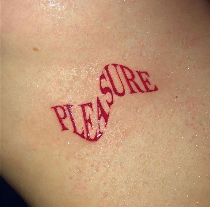 the word pleasure written in red ink on top of a woman's back shoulder