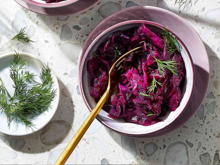 two bowls filled with red cabbage on top of a table