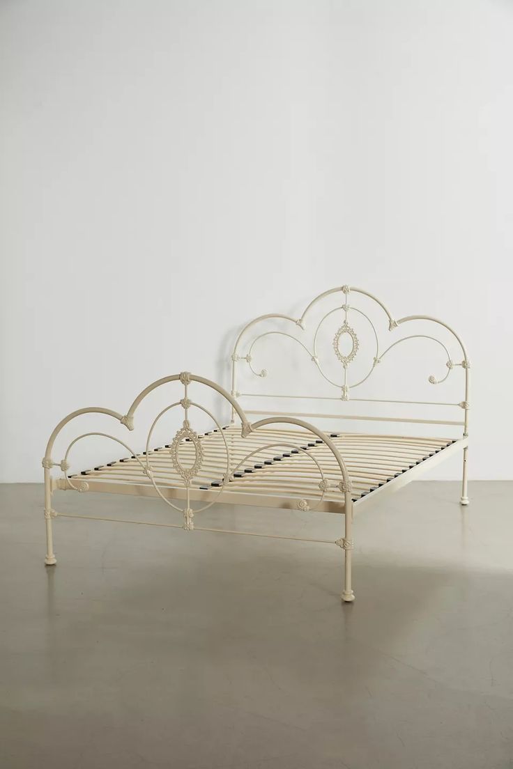 a white metal bed frame sitting on top of a floor