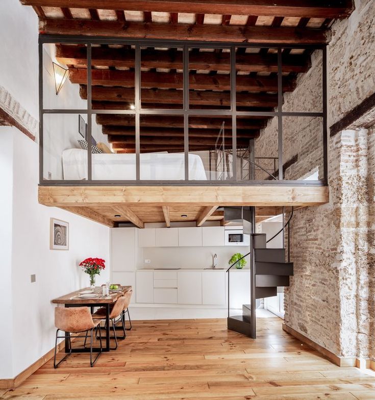 a loft apartment with wooden floors and exposed ceilings