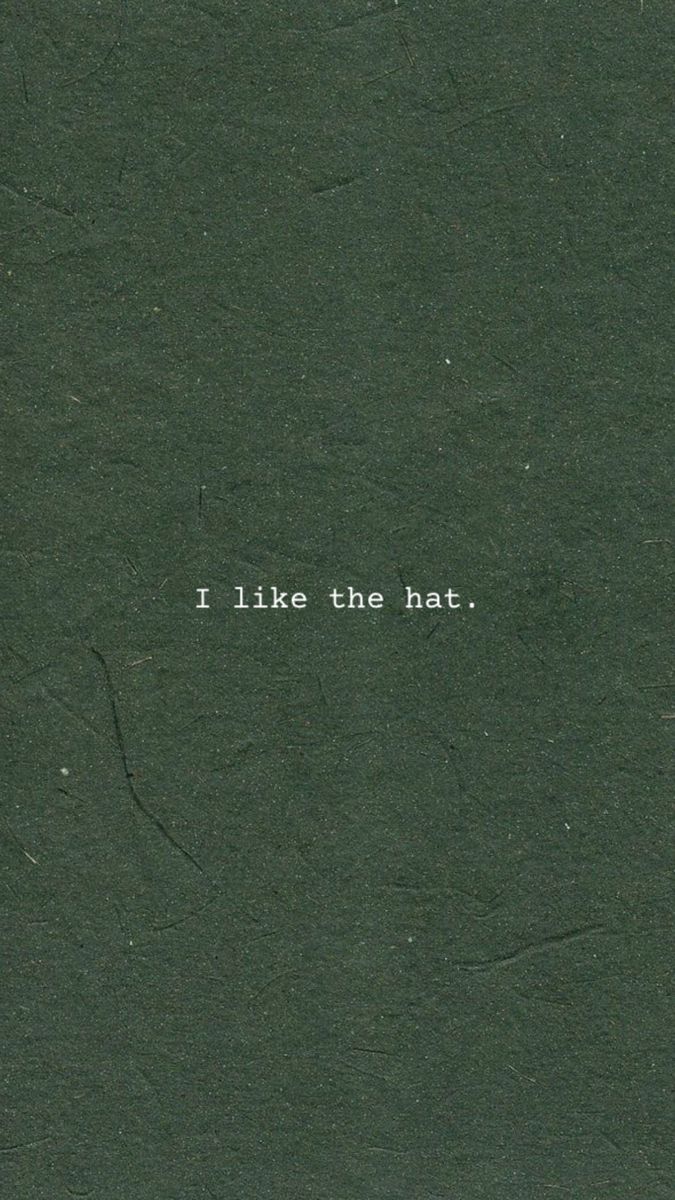 the words i like the hat are written in white on a dark green paper background