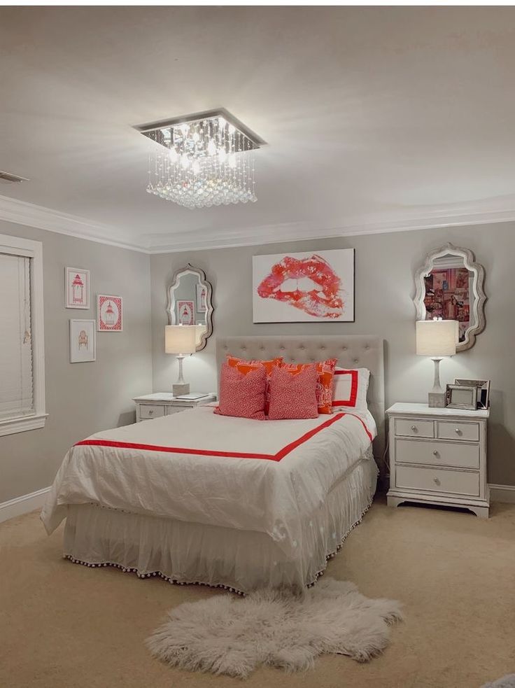 a white bed sitting in a bedroom under a chandelier