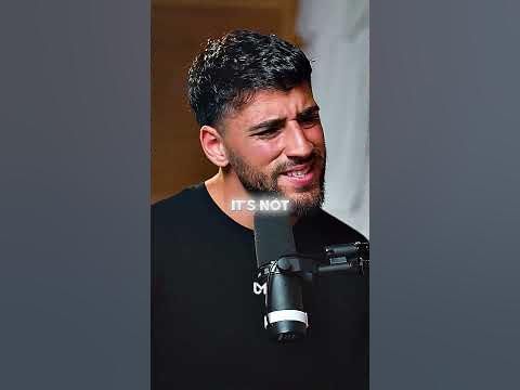 a man is talking into a microphone while wearing a t - shirt that says it's not