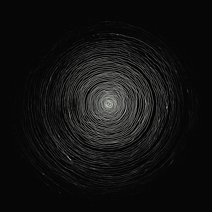 an abstract black and white photo with spirals in the center on a dark background