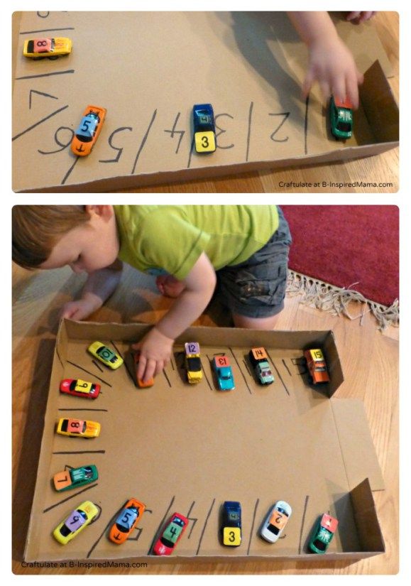 a child playing with toy cars in a cardboard box