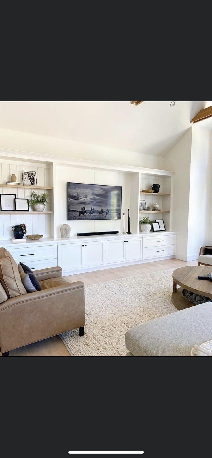 a living room filled with furniture and a flat screen tv mounted to the side of a wall