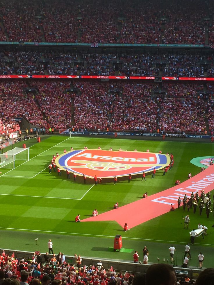 a stadium full of people watching a soccer game on a field with a giant banner in the middle