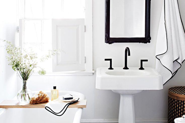 a bathroom with a sink, mirror and bathtub next to a window in it