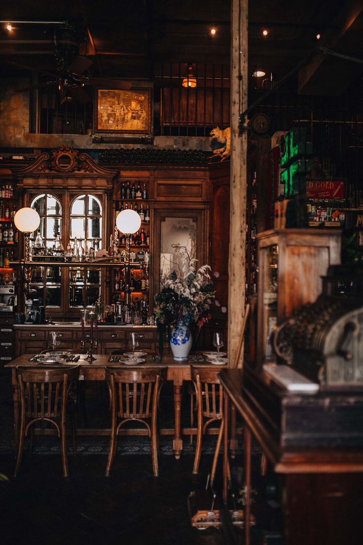 an old fashioned bar with wooden tables and chairs