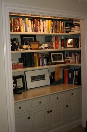 a bookshelf filled with lots of books next to a white cabinet and door