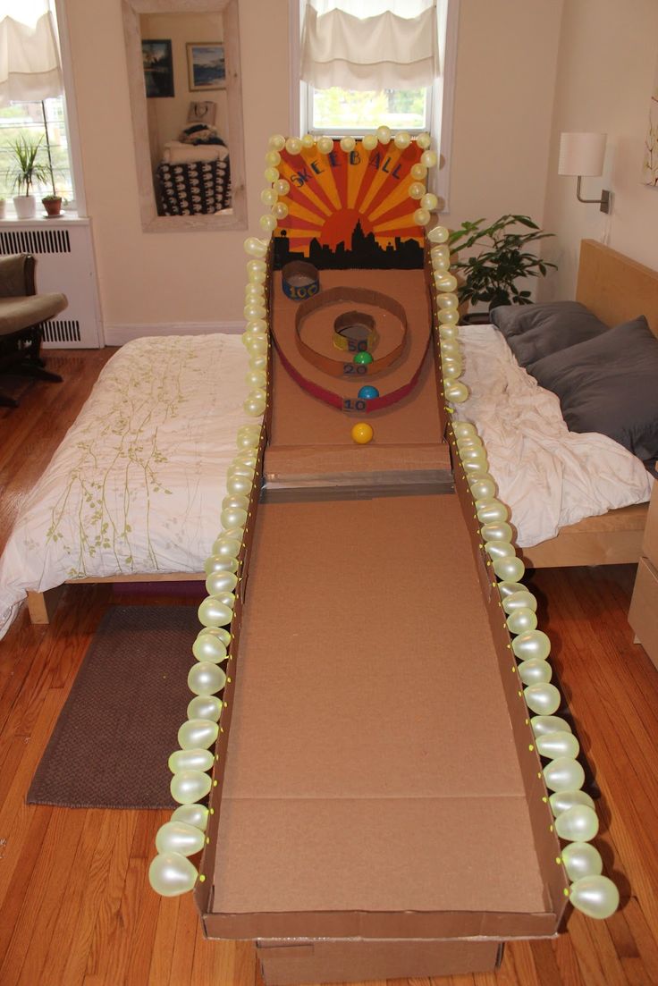 an open cardboard box with pearls and beads on the floor in front of a bed