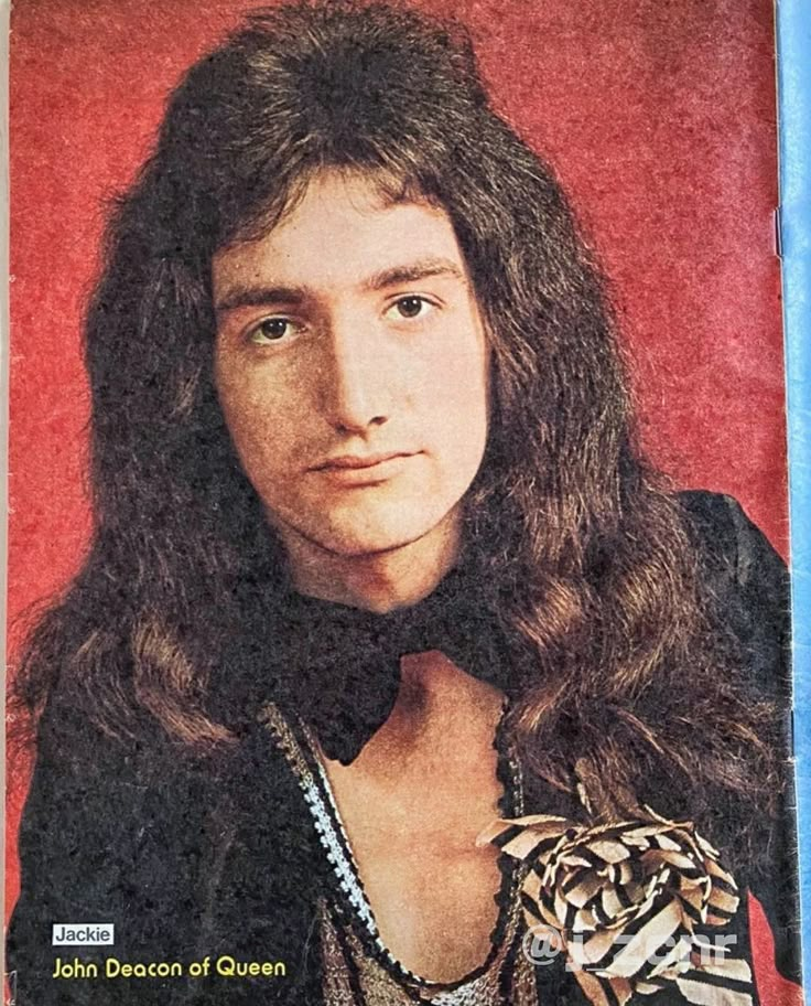 a man with long hair wearing a black shirt and necklaces on top of a magazine cover