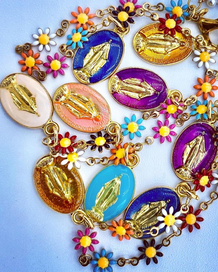 "The religious jewelry trend is an import from fashionistas in Paris and Milan. Nine enamel religious medals of the Virgin Mary or Blessed Mother, made in Milan, are strung on an enamel chain of colorful daisies that match the shades of the medals. Worn either for its spiritual or religious symbology or merely aesthetic value.  Sadie Salome offers a line of items perfectly on-point for this religious jewelry trend. Necklace length is 19.5\"   2\" gold chain necklace extender listed separately." Vintage Multicolor Jewelry With Flower Charm, Trend Necklace, Colorful Daisies, Blessed Mother Mary, Necklace Extender, Blessed Mother, Mother Mary, Religious Jewelry, Gold Chain Necklace