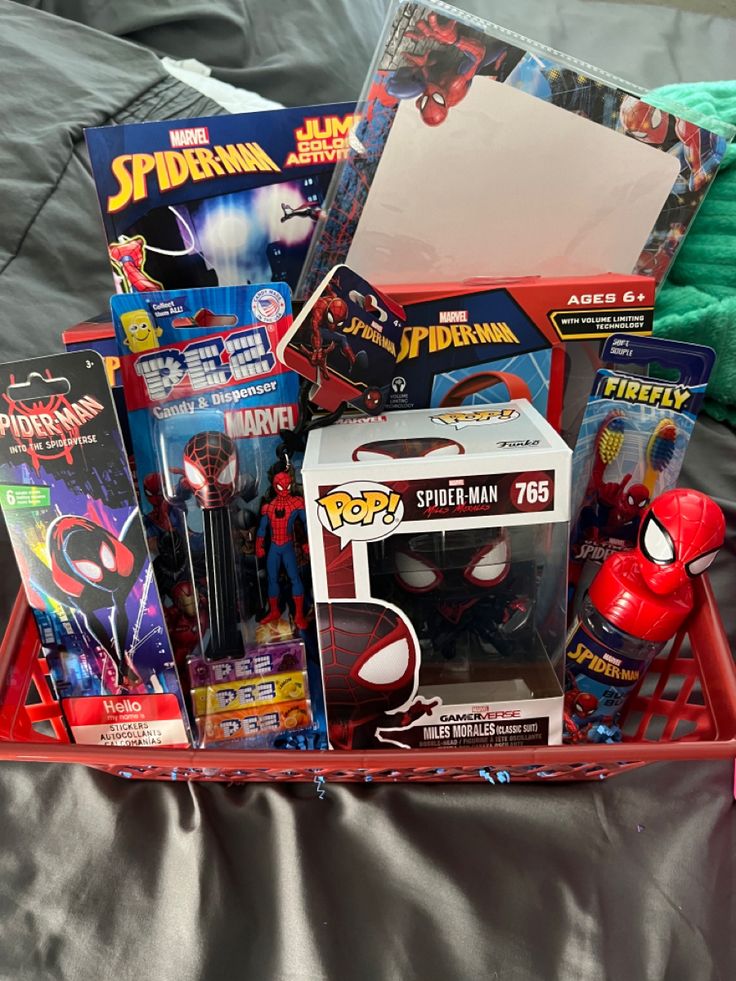 a red basket filled with toys on top of a bed