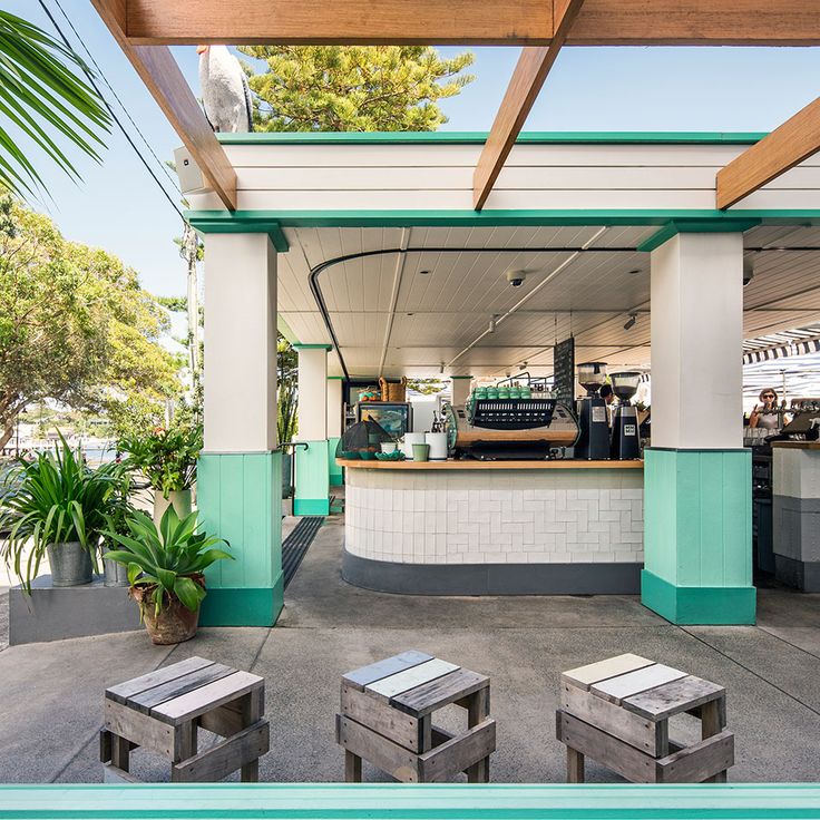 an outdoor restaurant with tables and stools next to the pool