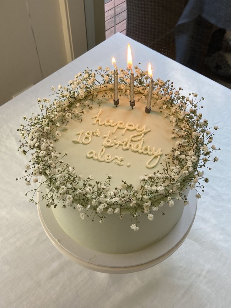 a birthday cake with white frosting and lit candles