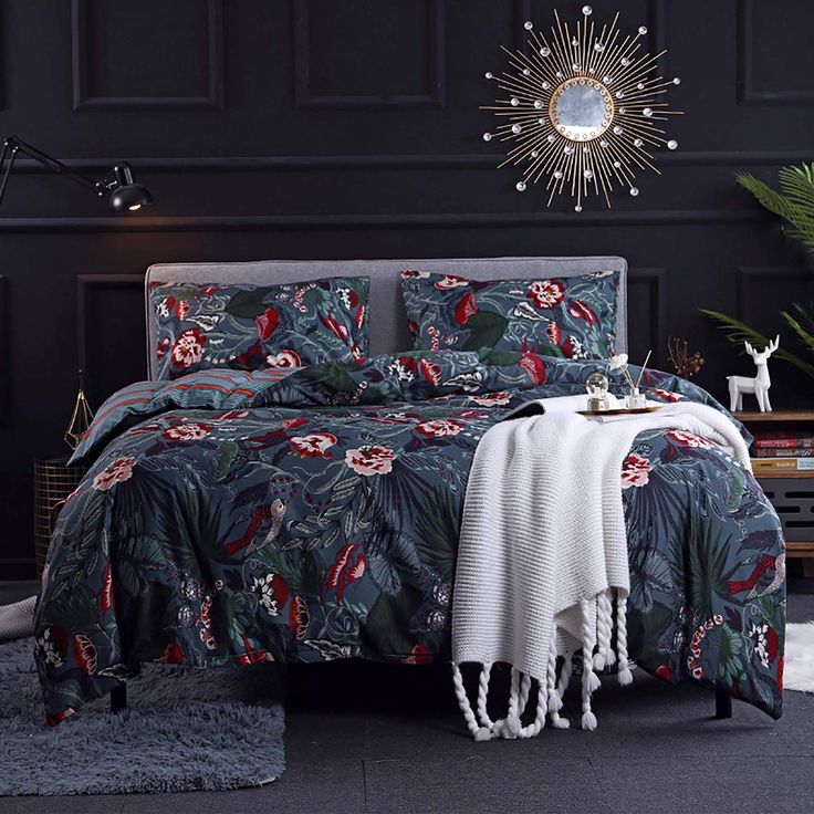 a bedroom with black walls and floral bedspread