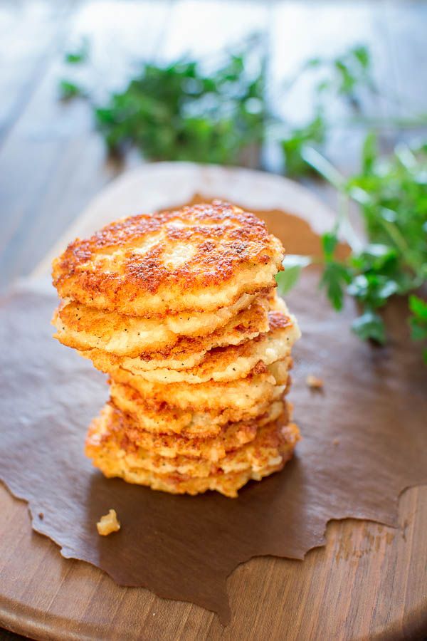 a stack of pancakes sitting on top of a wooden cutting board next to a plant