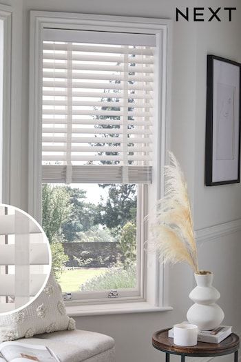 an image of a living room with white furniture and window blinds on the windowsill