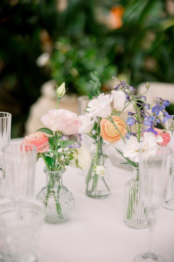 there are many vases with flowers in them on the table