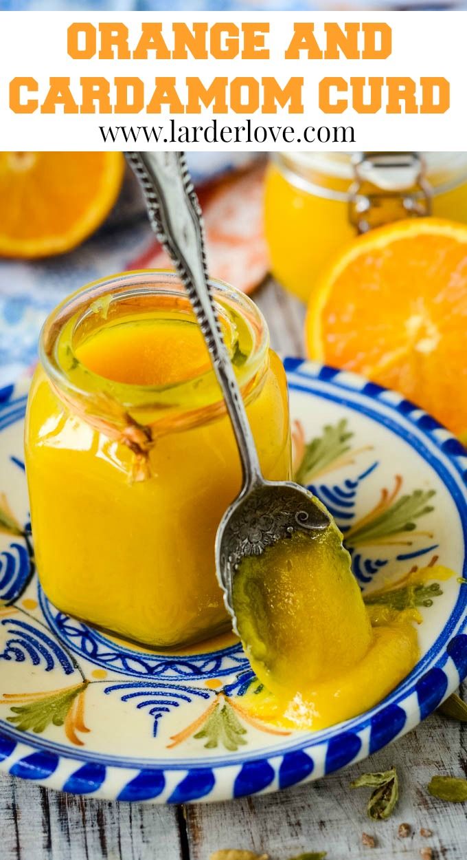 orange and cardamom curd in a jar on a plate with a spoon