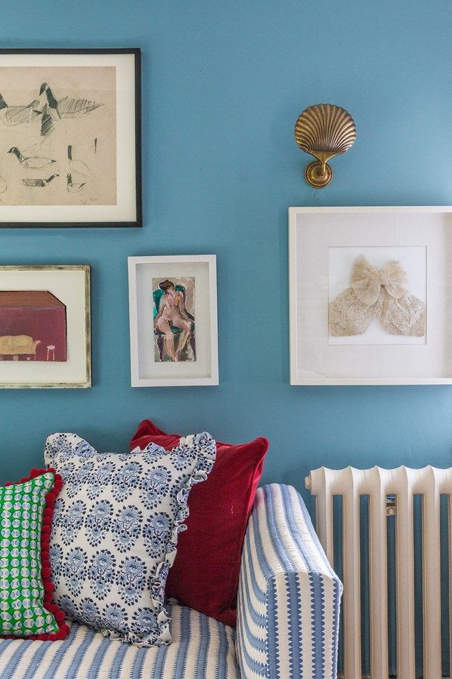 a bed with pillows and pictures on the wall next to it in front of a radiator