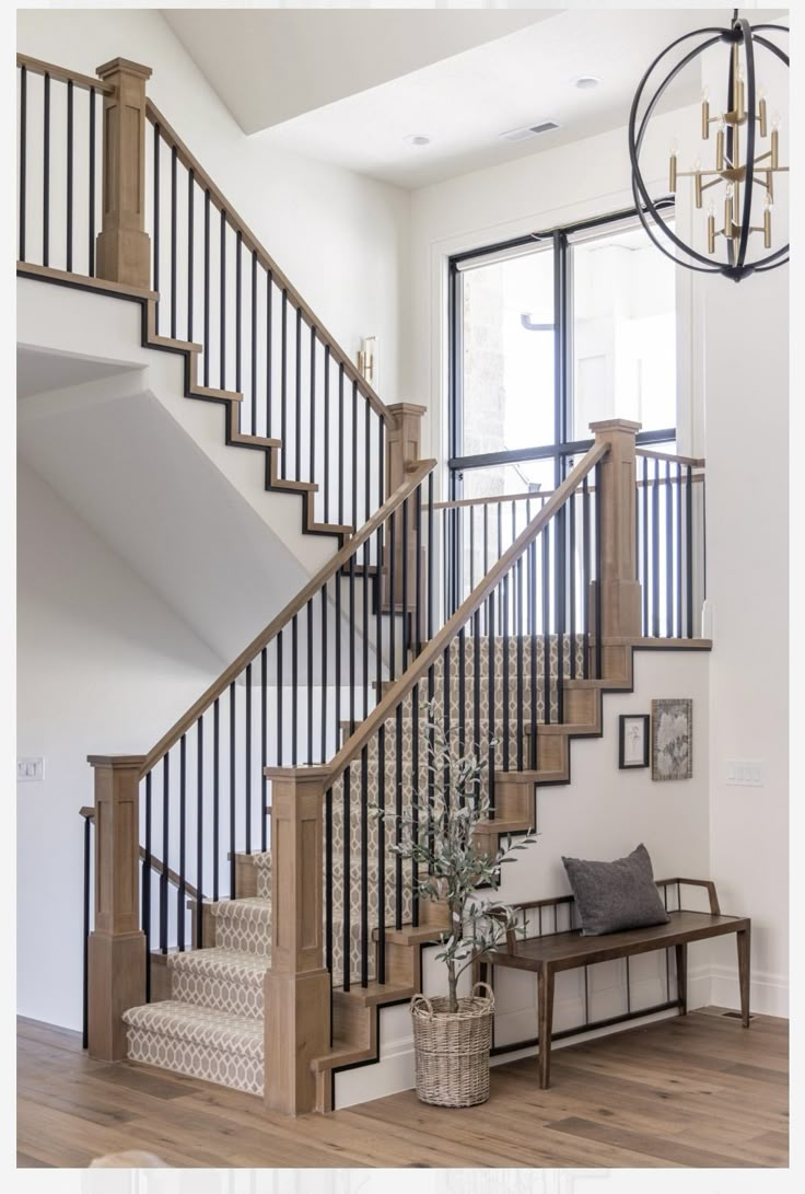 the stairs in this home are made of wood and wrought iron railings, along with a bench for seating