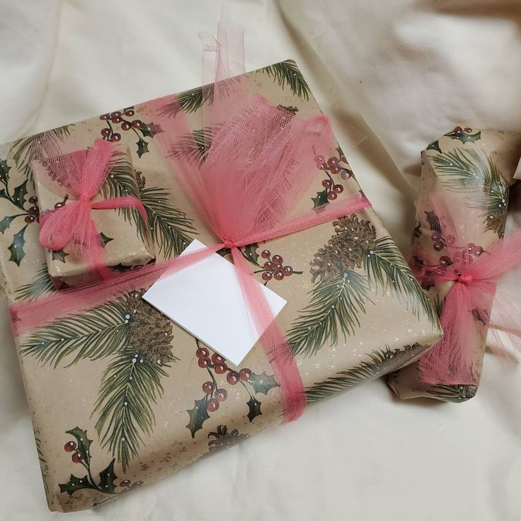 two wrapped presents with pink ribbons and bows