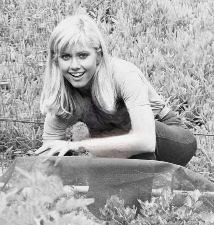 a black and white photo of a woman laying on the ground