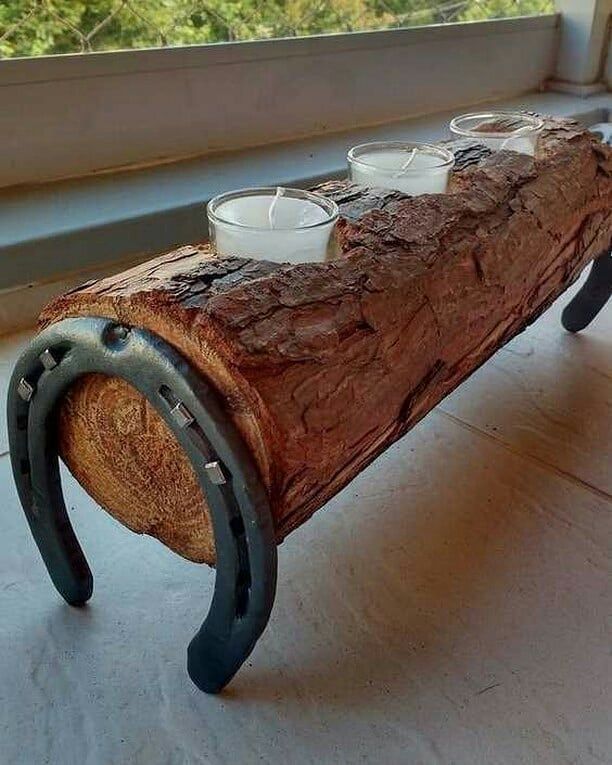 a bench made out of a log with tea cups on it sitting in front of a window