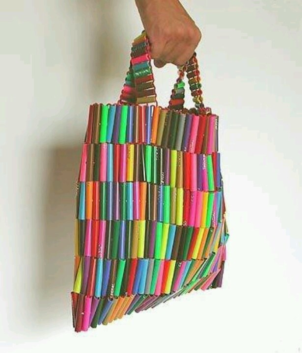 a hand is holding a multicolored bag made out of crayon sticks