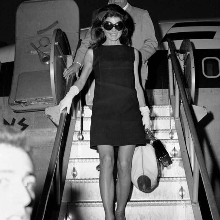 a woman walking down an escalator next to a man