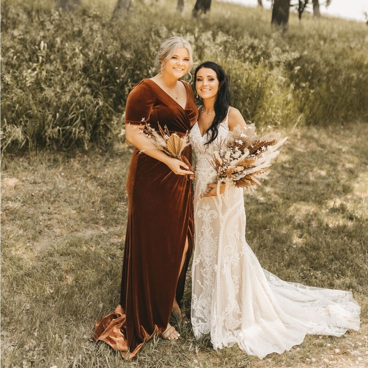 two women standing next to each other in a field