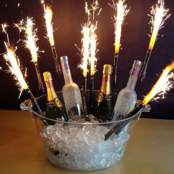 there are many champagne bottles in the ice bucket with sparklers on it and some bubbles