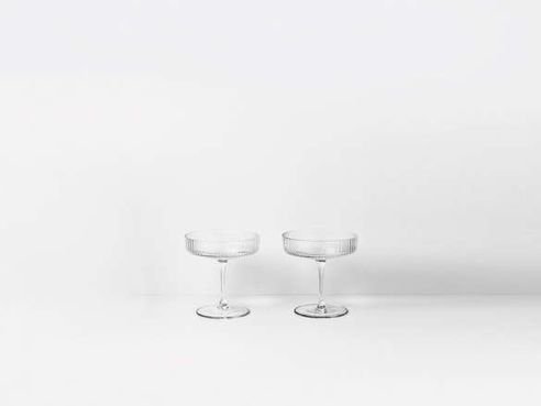 two wine glasses sitting side by side on a white surface