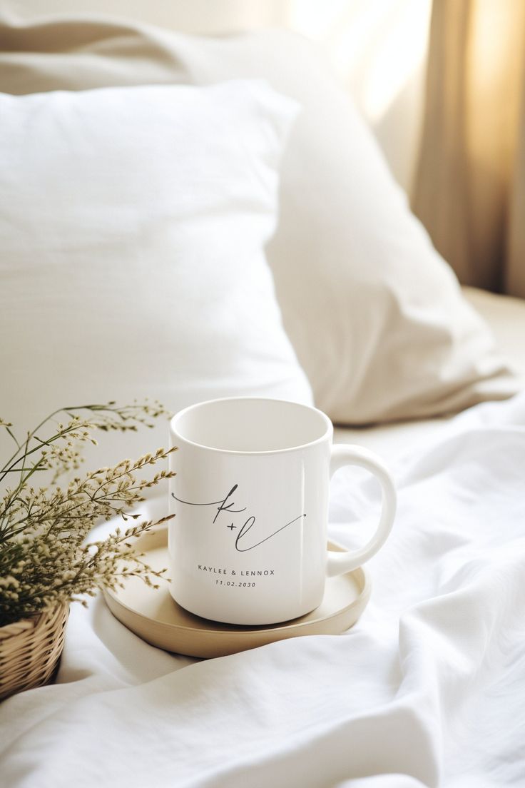 a white coffee mug sitting on top of a bed