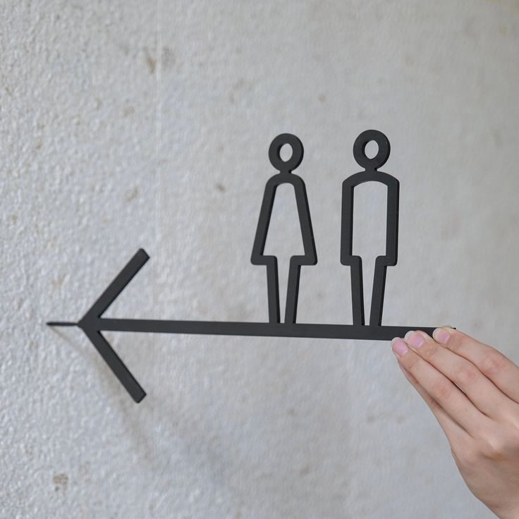 a hand is holding a paper cutout of two people on a sees - bar