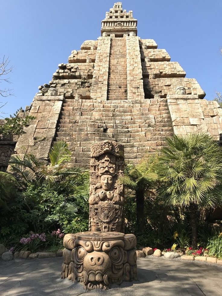 a stone statue in front of a tall building