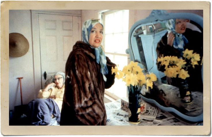 a woman standing in front of a blue mirror